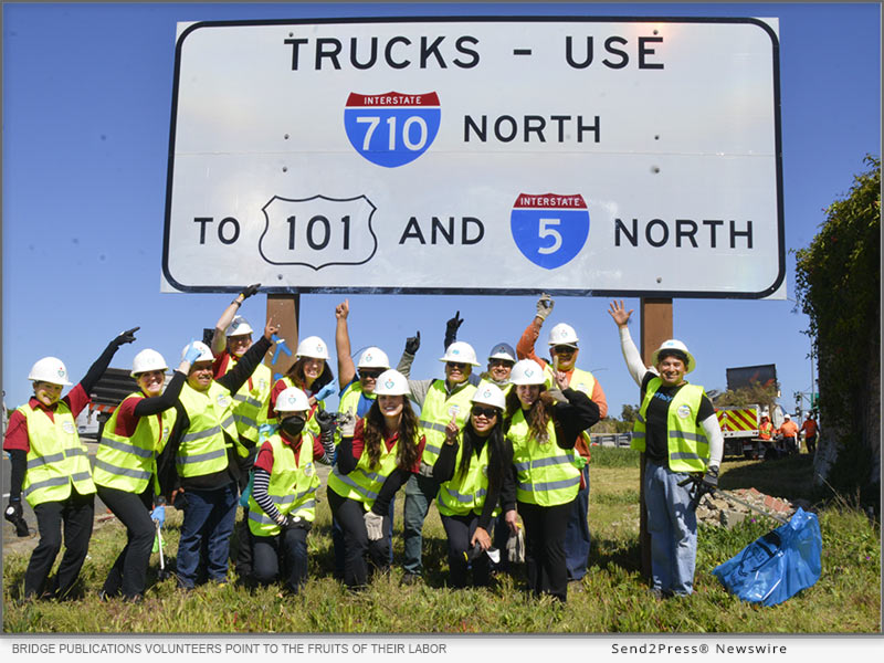 Volunteers proudly point to the fruits of their labor — a graffiti-free freeway sign and an on-ramp free of debris